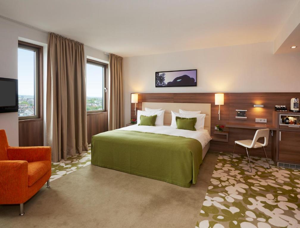 a bedroom with a large bed and a large window at Meliá Düsseldorf in Düsseldorf