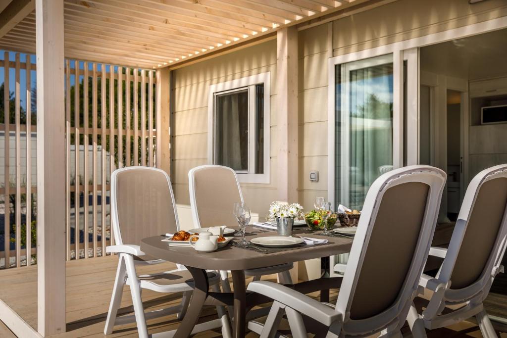 a dining room with a table and chairs at Maistra Camping Valkanela Mobile homes in Funtana