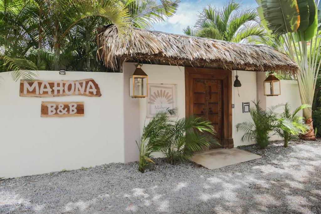 a small white building with a thatch roof at Mahona Boutique Hotel in Las Terrenas