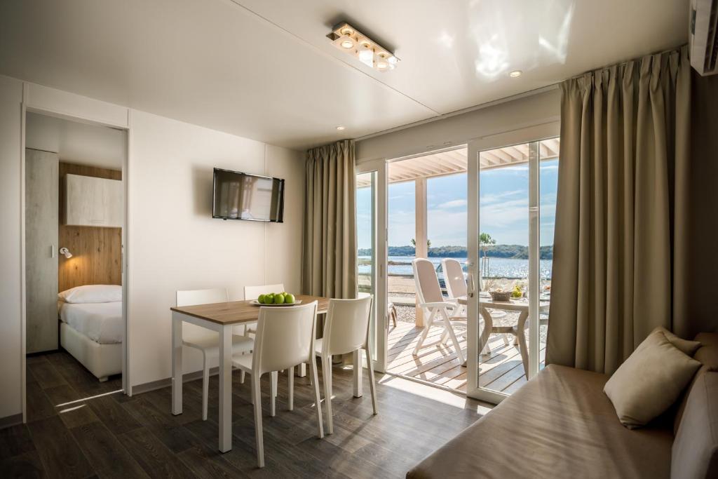 a hotel room with a bed and a table and chairs at Maistra Camping Valkanela Mobile homes in Funtana