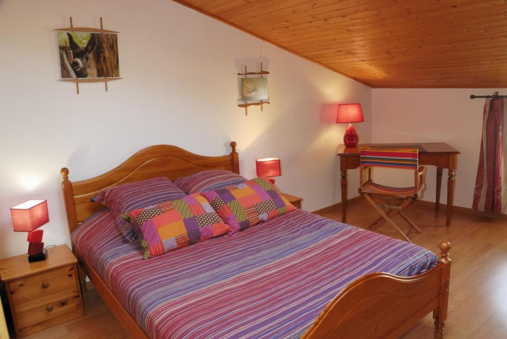 a bedroom with a bed and a desk with two lamps at La Ferme du Marais Poitevin - Chambre d'hôtes in Benet