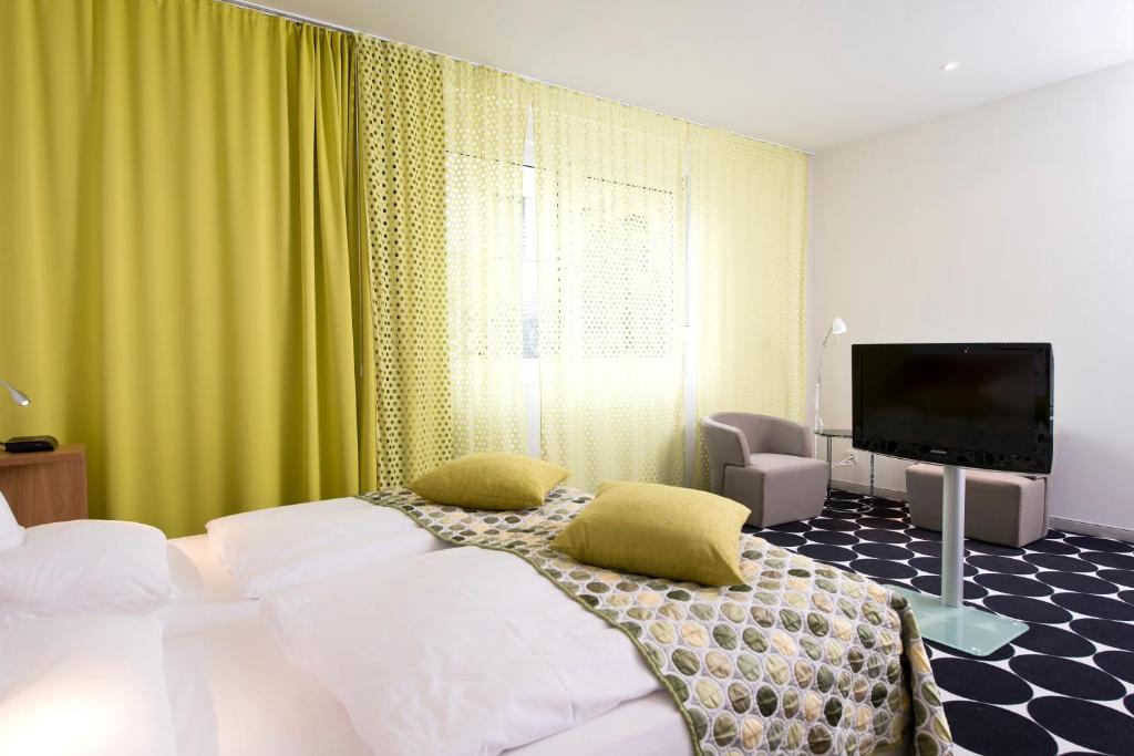 a bedroom with a bed and a flat screen tv at Tryp by Wyndham Frankfurt in Frankfurt