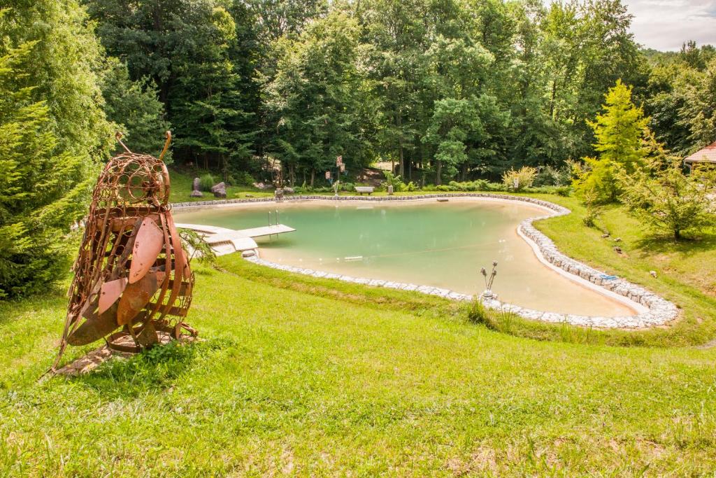 a sculpture of a boat in the grass next to a pond at Country house with a pool in Medvednica Nature Park in Zagreb