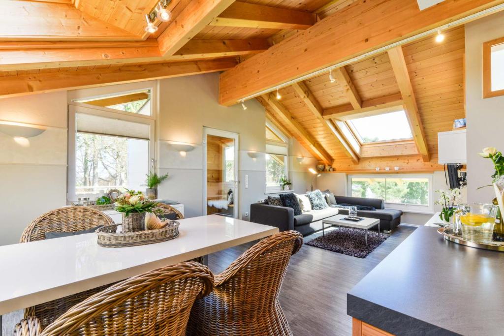 a kitchen and living room with wooden ceilings at 5 Sterne Ferienwohnung am See in Böbing