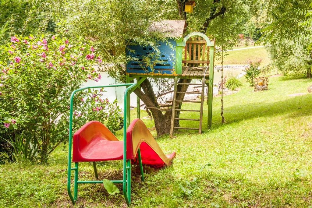 a playground with a red chair and a slide at Country house with a pool in Medvednica Nature Park in Zagreb