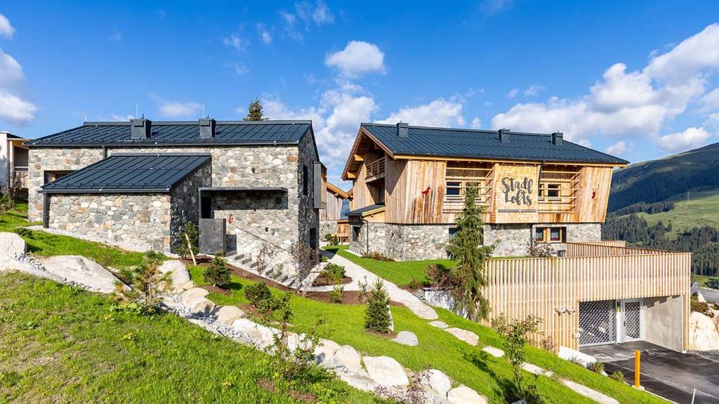 kamienny dom z czarnym dachem na wzgórzu w obiekcie Stadl Lofts Plattenalm - Premiumchalets - Zillertal - Tirol - Salzburg w mieście Krimml
