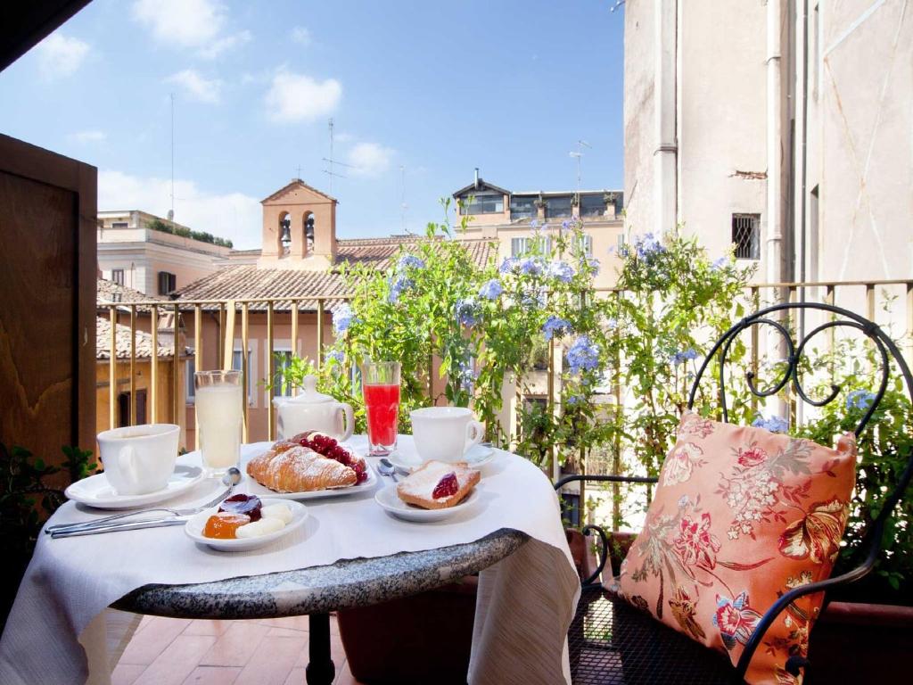 a table with food and drinks on a balcony at Pantheon Inn in Rome