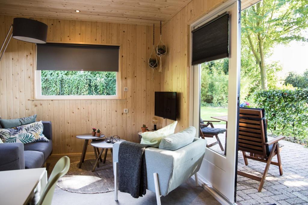 - un salon avec un canapé et une télévision dans l'établissement vakantiehuisje "ZUSJE", à Bruchterveld