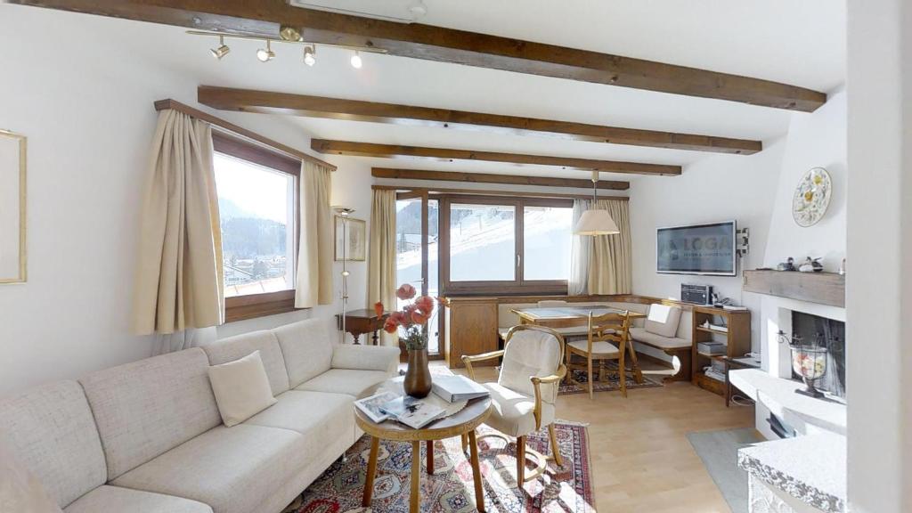 a living room with a white couch and a table at Polaschin in Celerina