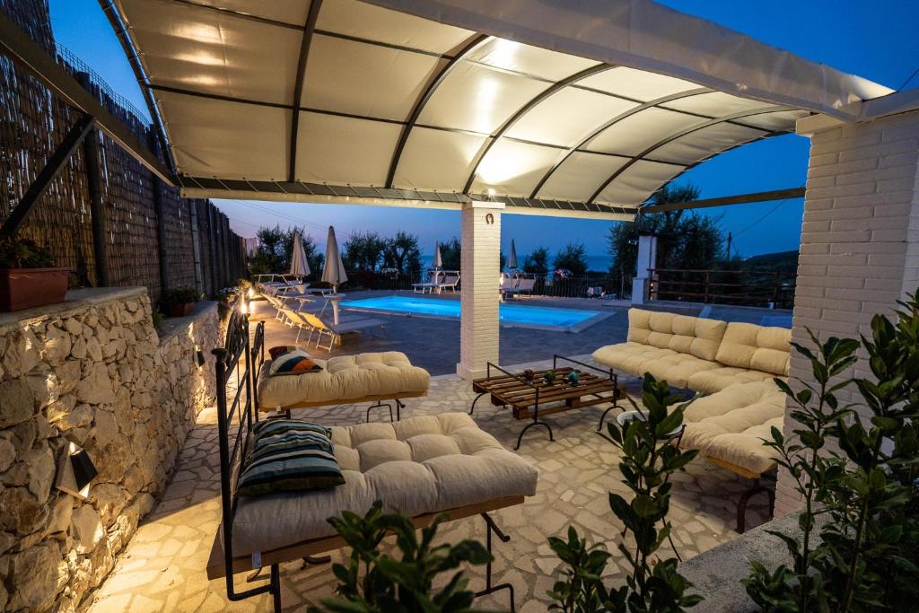 a patio with a white umbrella and chairs and a pool at Borgo Canneto in Rodi Garganico