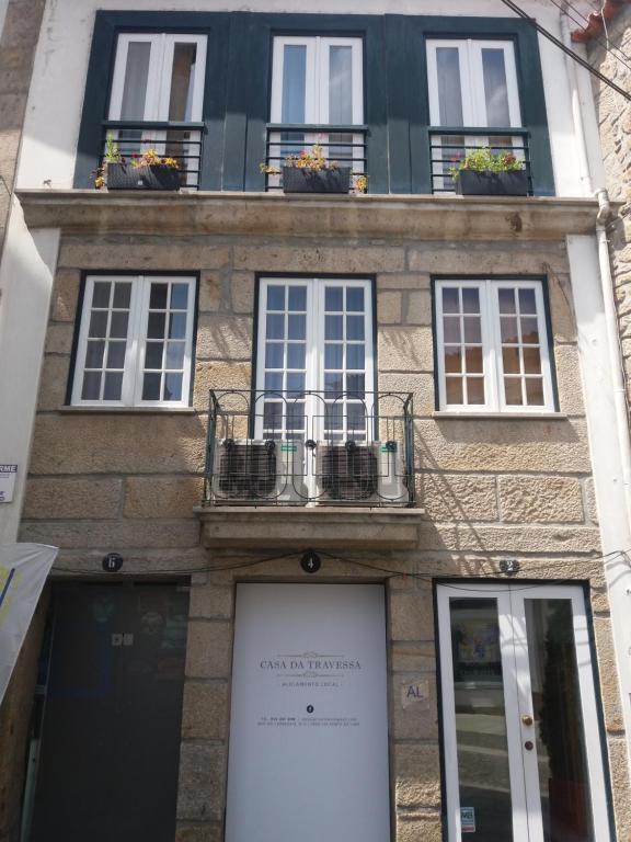 a building with windows and potted plants on it at Casa da Travessa in Ponte de Lima