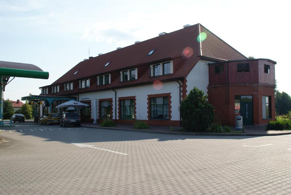 a large building with a parking lot in front of it at Motel Warmiaki Bed&breakfast in Jadów