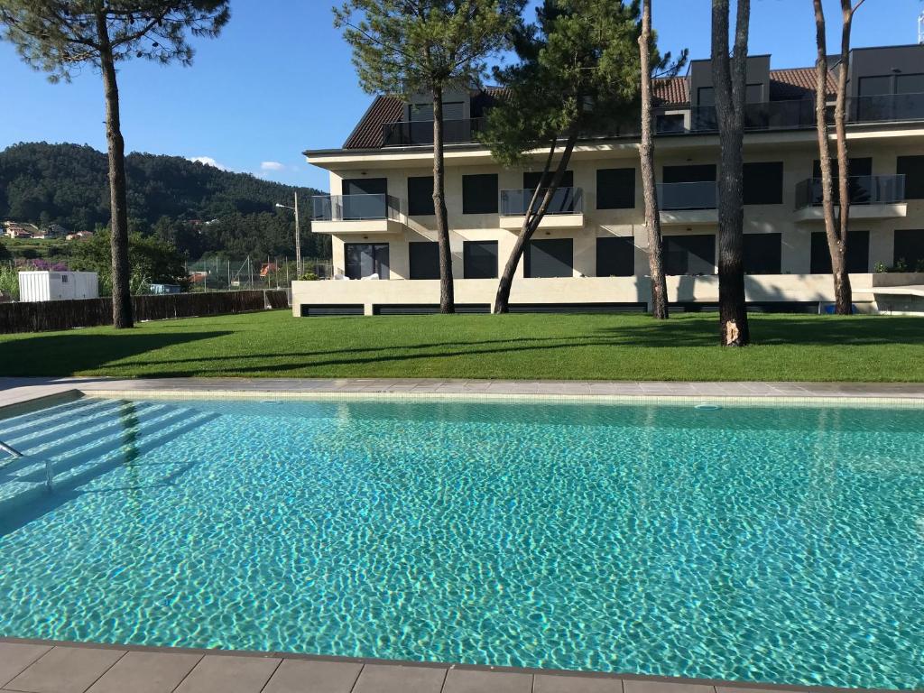 una piscina frente a un edificio en Apartamentos Areas en Sanxenxo