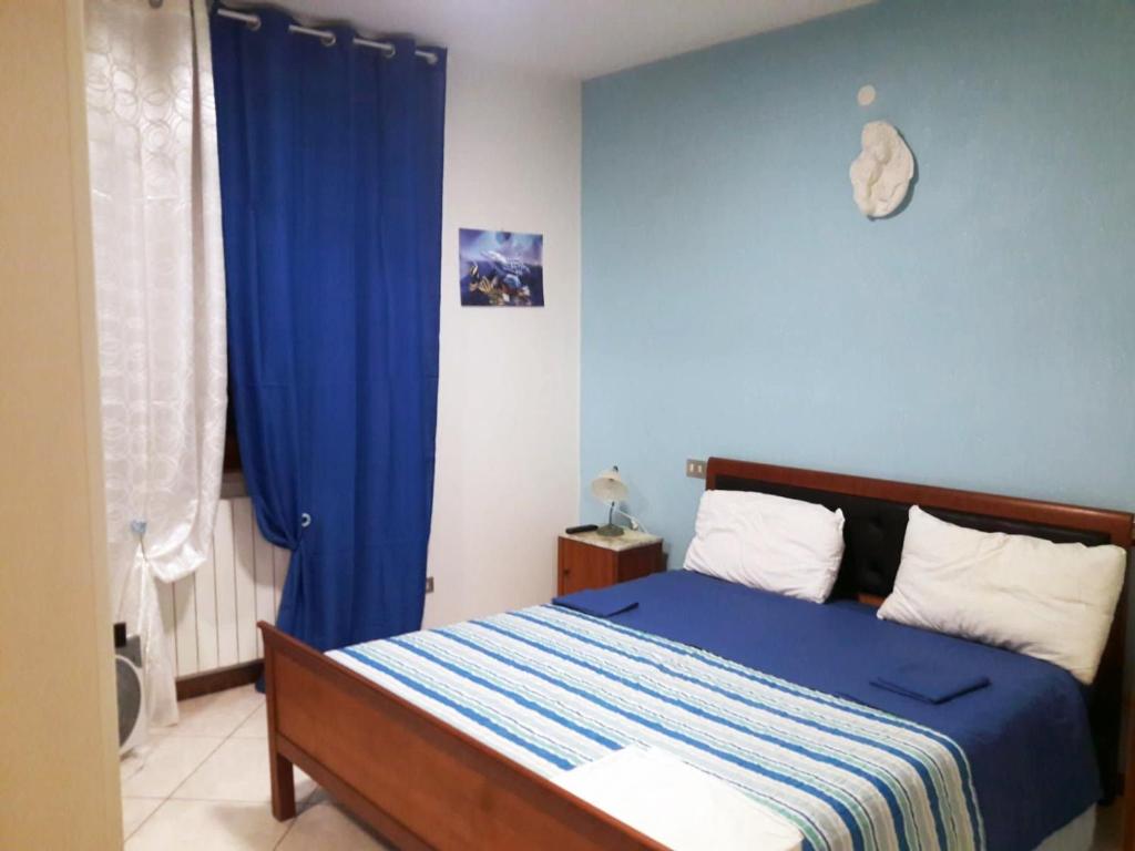 een slaapkamer met een bed en een blauwe muur bij Affittacamere Lo Scoiattolo di Mannocchi Lorella in Porto SantʼElpidio