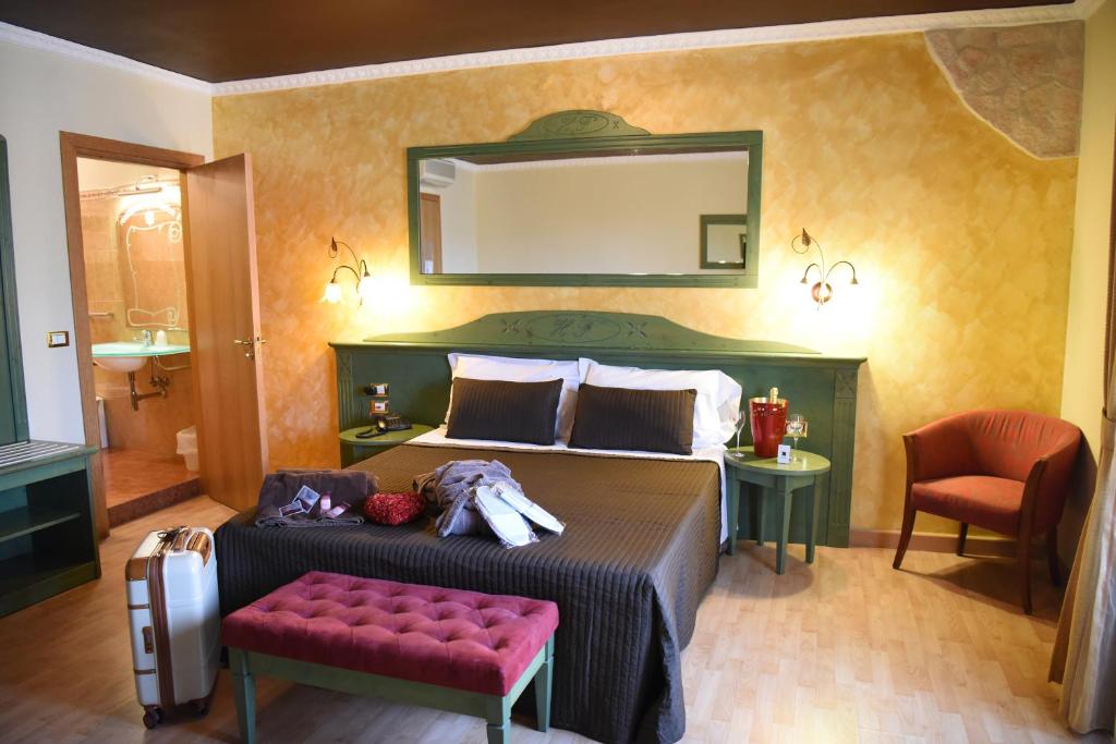 1 dormitorio con cama y espejo en la pared en Hotel Federico II, en Lucera