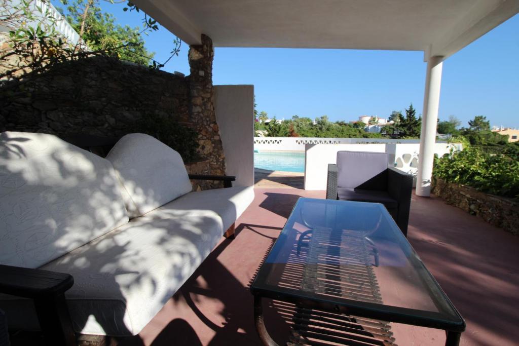 a patio with a couch and a table and a pool at Casa do Milho in Carvoeiro