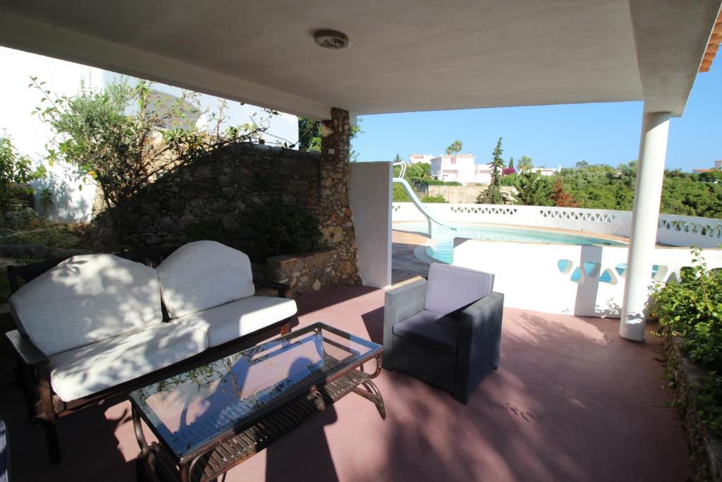 a patio with a couch and a table and a pool at Casa do Milho in Carvoeiro