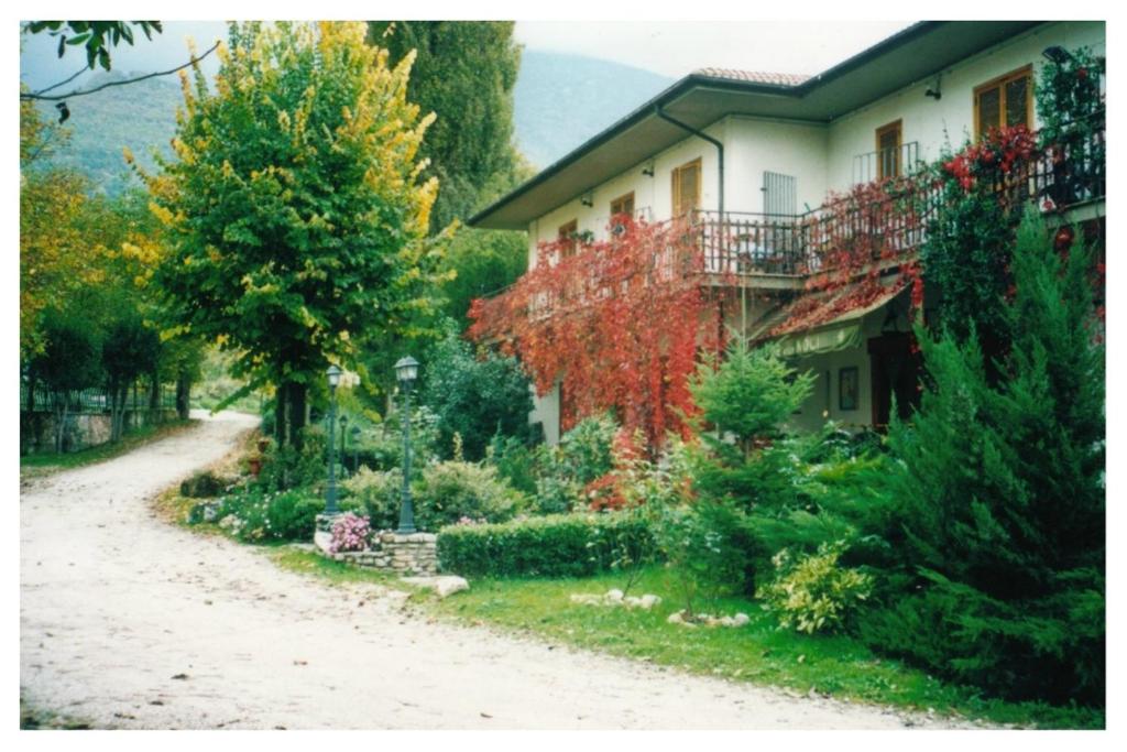 ein Haus mit Garten neben einer unbefestigten Straße in der Unterkunft Albergo-Ristorante"Parco alle Noci"tra la Cascata delle Marmore,Labro e valle Santa di S Francesco in Rivodutri