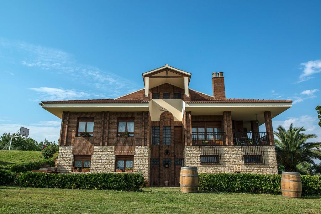 a large brick house with a roof at Casa Pichon Etxea in La puebla de Labarca 