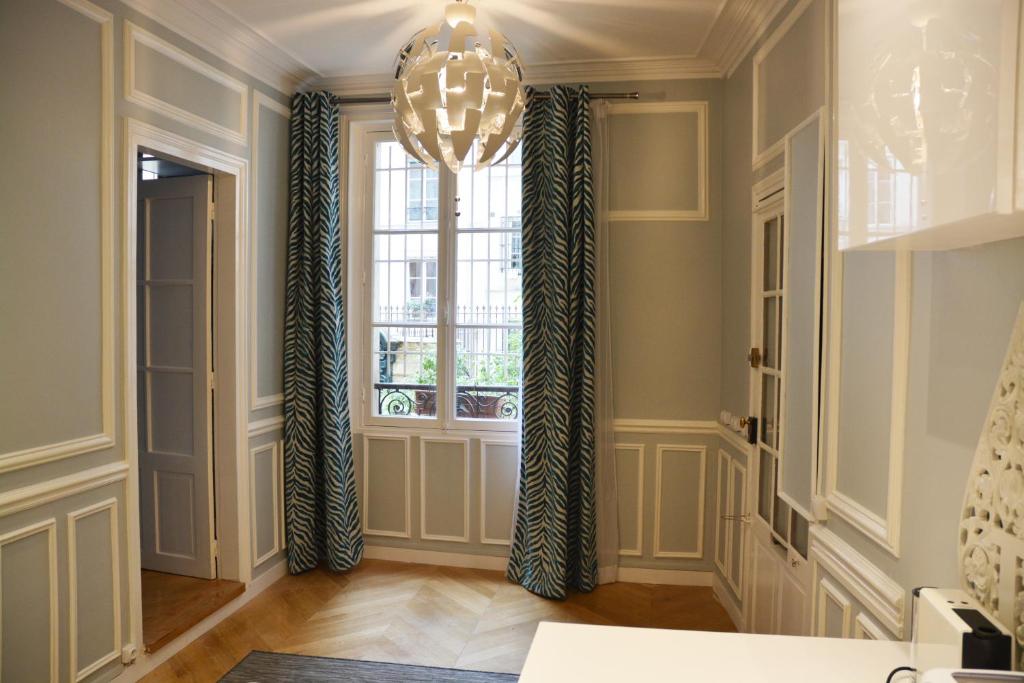 a hallway with a window and a chandelier at Residence sur Cour in Paris