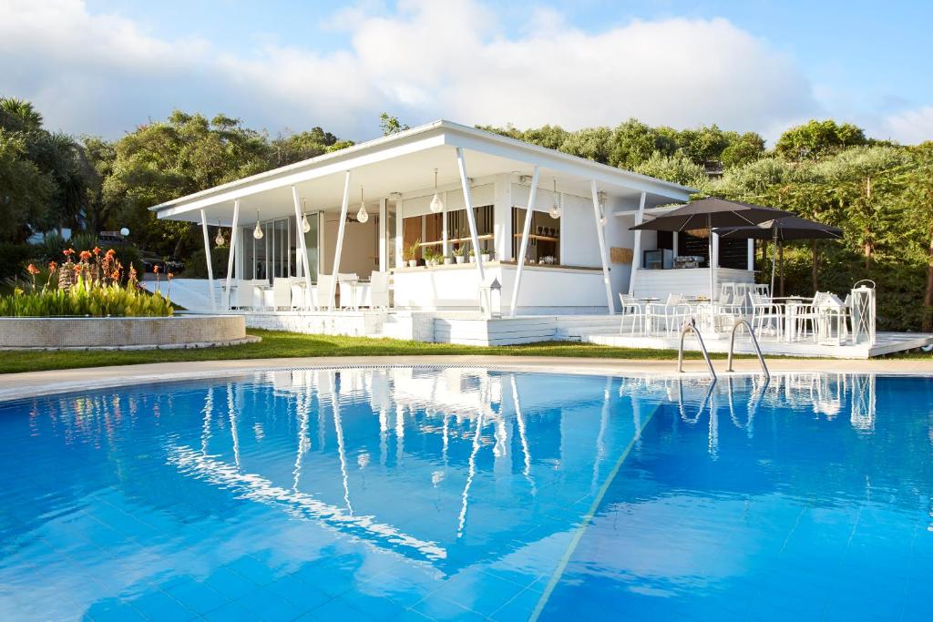 a white house with a pool in front of it at Mr and Mrs White Corfu Couples Retreat Adults Only in Acharavi