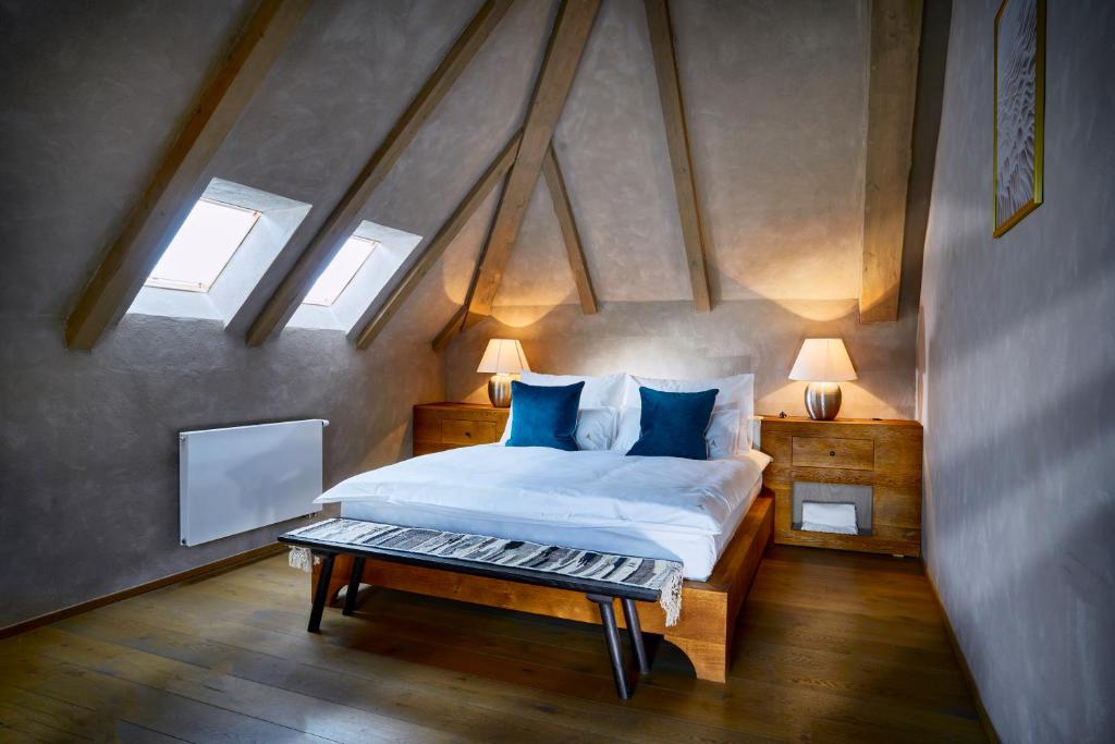 a bedroom with a large bed with blue pillows at Apartmány Vinice Salabka in Prague