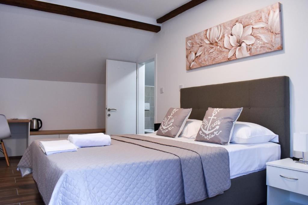 a bedroom with two beds and a painting on the wall at Airport room's Residence Garden in Velika Gorica