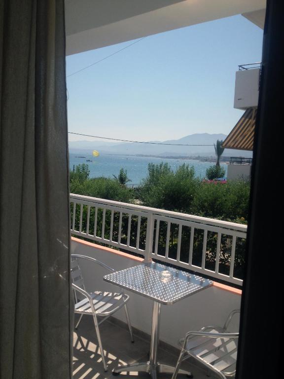 a balcony with a table and chairs and a view of the ocean at Hotel Thisvi in Stalís