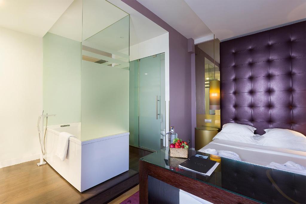 ヴィーラ・プライア・デ・アンコラにあるHotel Meiraのベッドルーム(紫色の大型ヘッドボード、ベッド1台付)