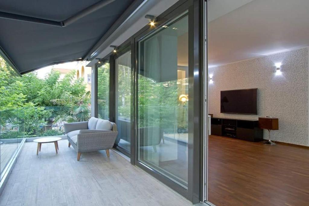 ein Wohnzimmer mit Glasschiebetüren und einem TV in der Unterkunft Central STEMA Luxury in Misano Adriatico