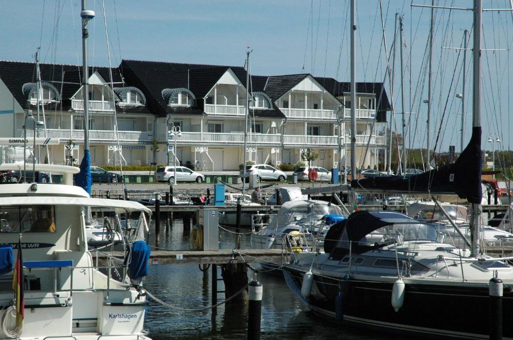 a group of boats docked in a marina with a building at Hafenidyll mit Wasserblick in Ostseebad Karlshagen