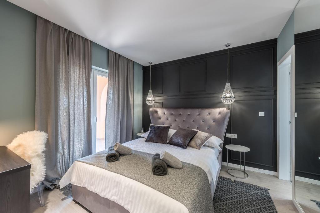 um quarto com uma cama grande e paredes pretas em Luxury Apartments Garden em Sukošan