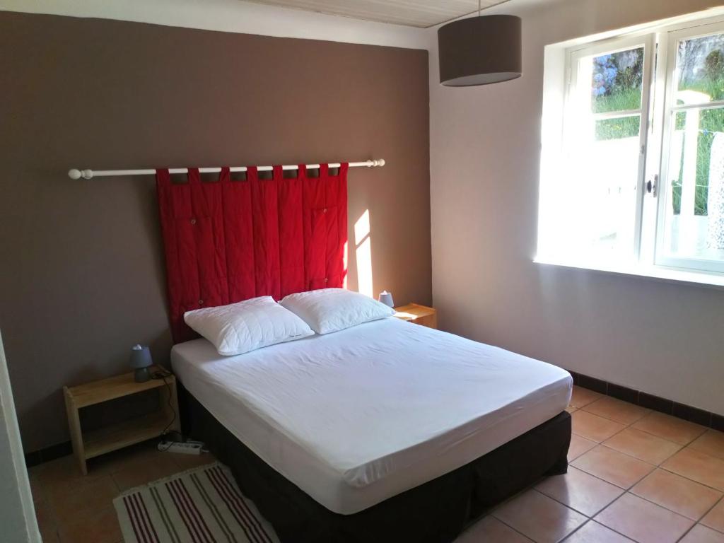 sypialnia z łóżkiem z czerwoną zasłoną w obiekcie Hendaye location w mieście Hendaye