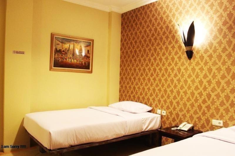 1 dormitorio con 2 camas y una foto en la pared en Twins Hotel, en Yakarta