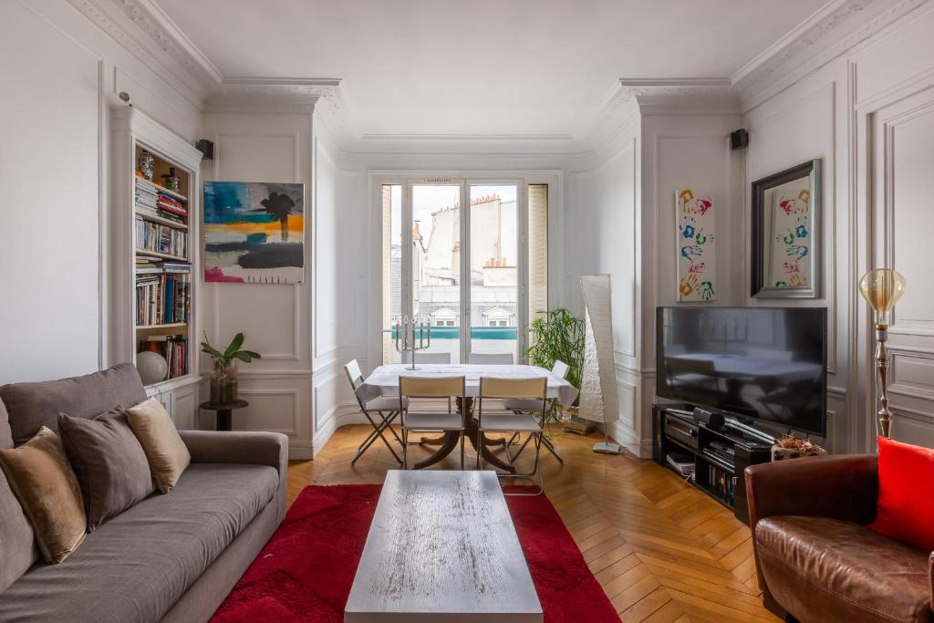 sala de estar con sofá y mesa en Veeve - Balcony Bliss, en París