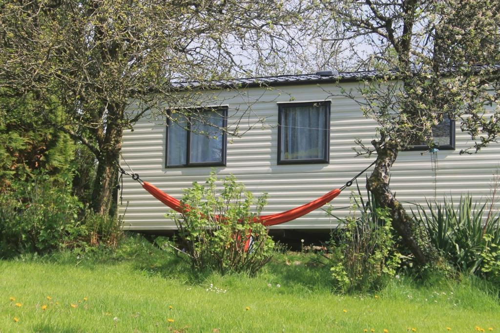 a hammock in front of a house at The Valley Static Caravan in Pembrokeshire