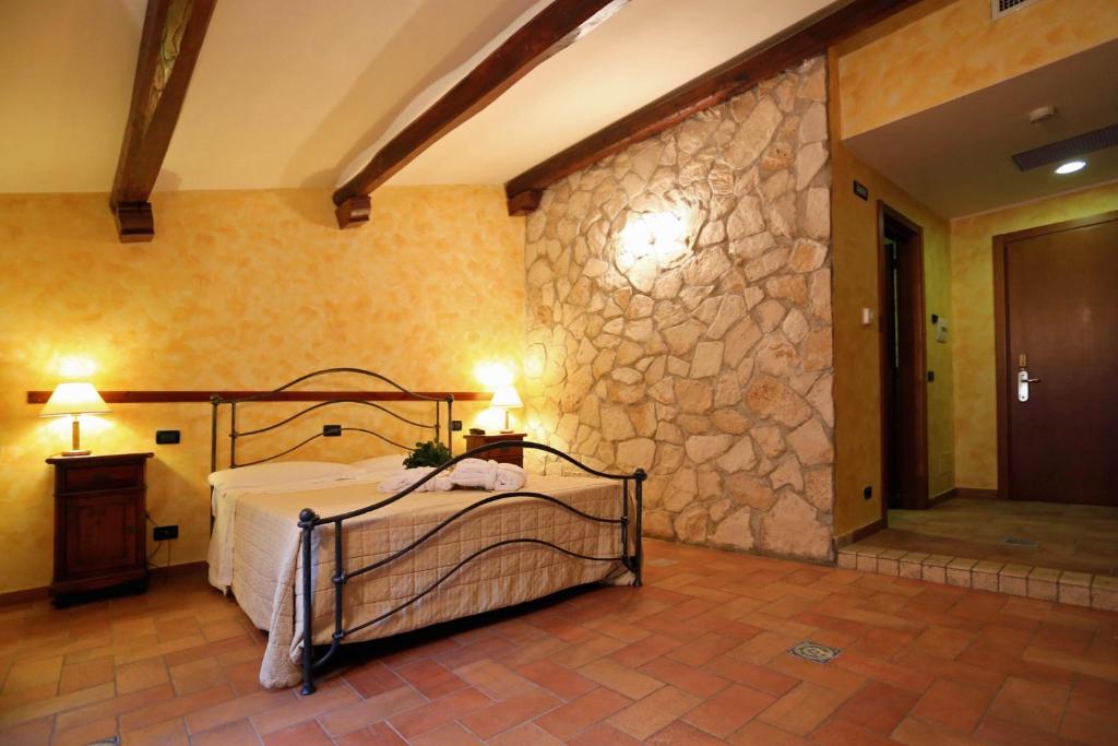 a bedroom with a large bed and a large window at Hotel L'Aquila in LʼAquila