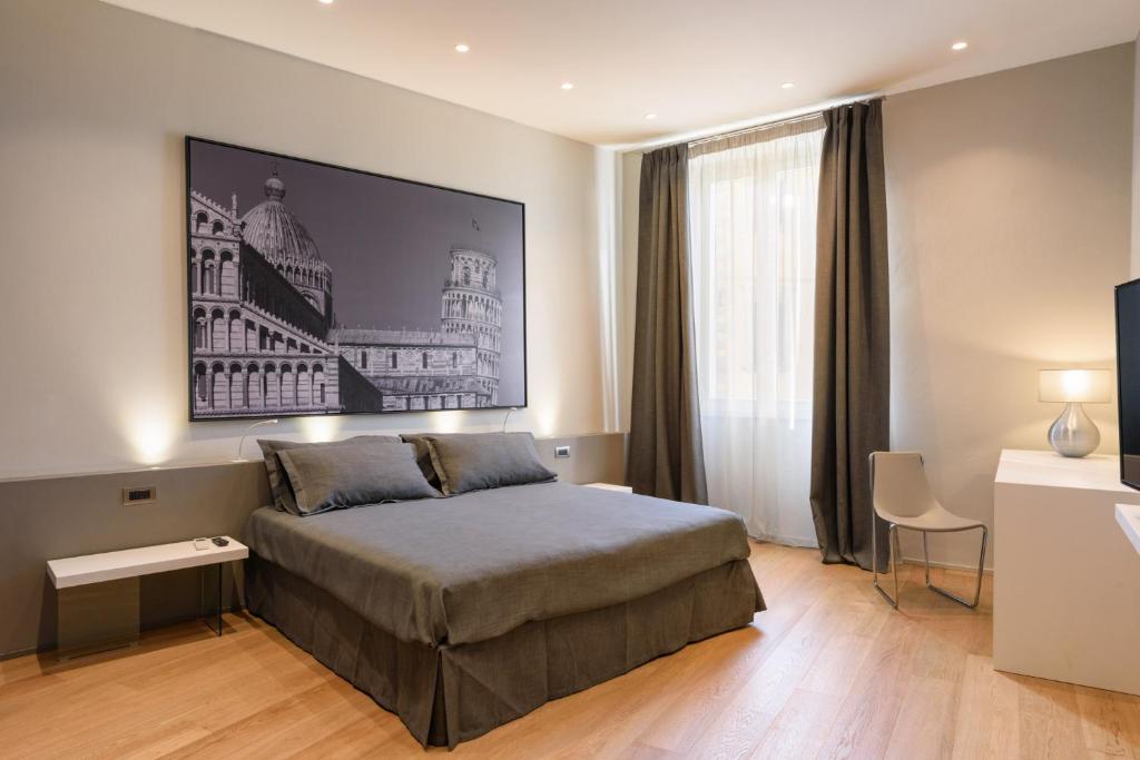 モンテヴァルキにあるPalazzo Vasarri - Luxury design suitesのベッドルーム1室(ベッド1台付)が備わります。壁には大きな絵画が飾られています。