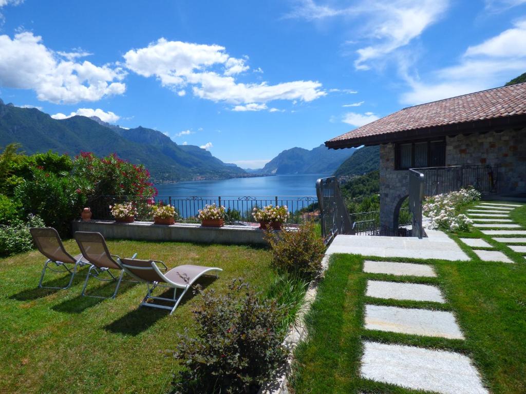 ein Haus mit Stühlen und Blick auf das Wasser in der Unterkunft ALBA e TRAMONTO Appartamenti vista lago in Bellagio