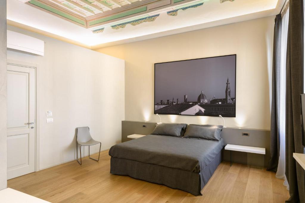 een slaapkamer met een bed en een tv aan de muur bij Palazzo Vasarri - Luxury design suites in Montevarchi