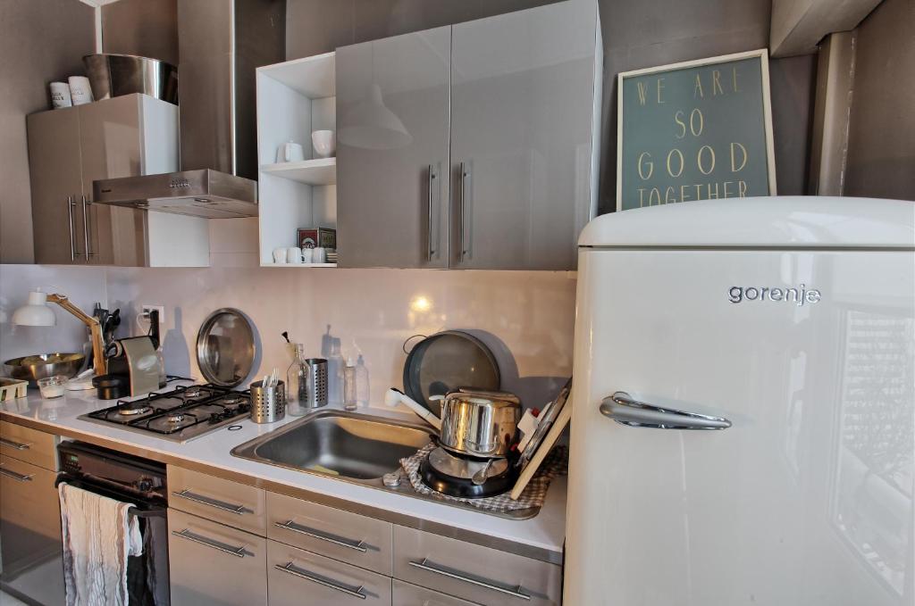 a kitchen with a white refrigerator and a sink at Appartement type parisien 75m² in Beauvais