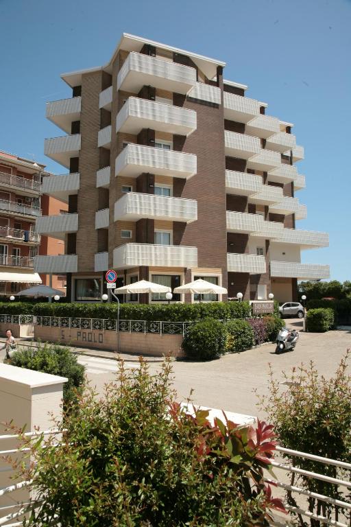a large apartment building in front of a parking lot at Residence San Paolo in Lido di Savio