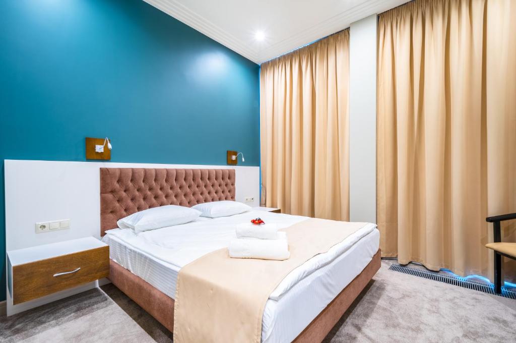 モスクワにあるRibella Hotelの青い壁のベッドルーム1室(ベッド1台付)