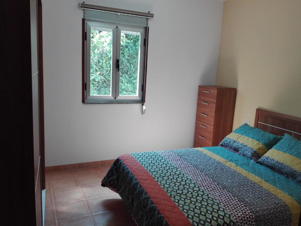 1 dormitorio con cama y ventana en Apartamento A Nave, en Finisterre