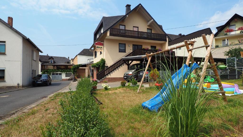 un parque infantil en un patio frente a una casa en Ferienwohnung Gerhard Lenz, en Ellenz-Poltersdorf