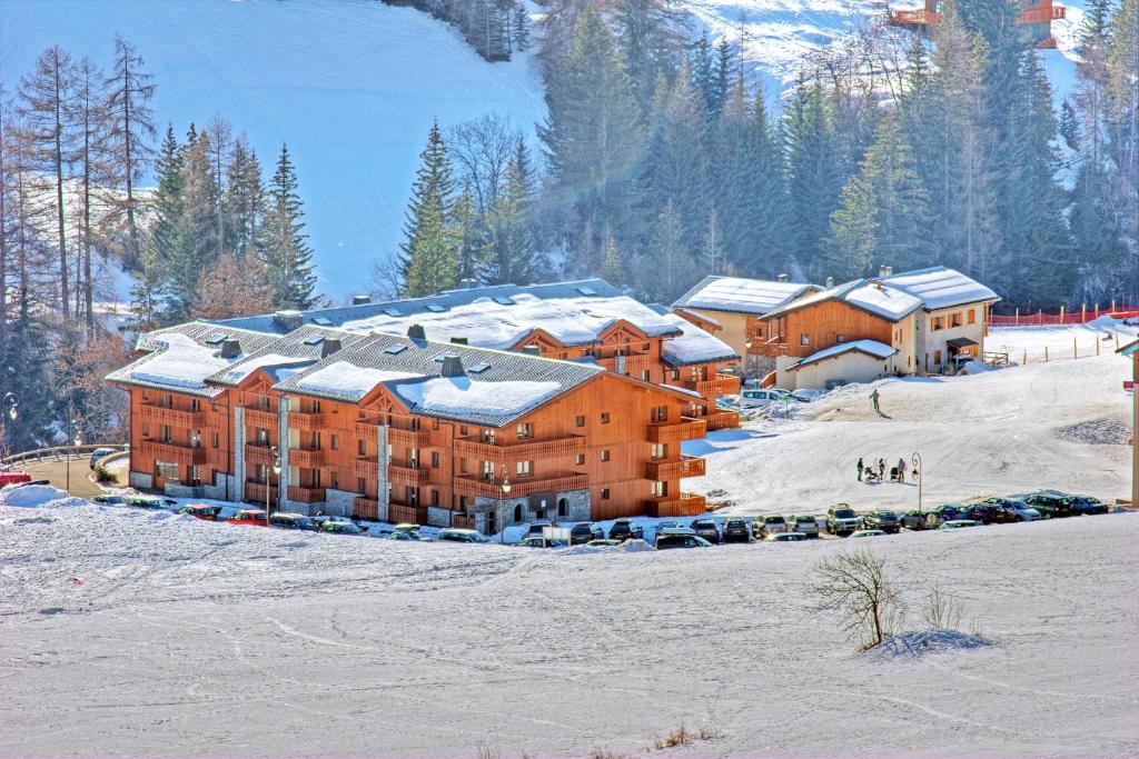 a large building with snow on it in the snow at Résidence Les Balcons De Val Cenis Le Haut in Lanslevillard