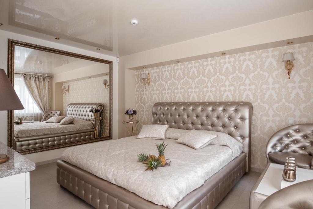 a bedroom with a large bed and a mirror at Jacuzzi Apartamentai Relaks in Klaipėda