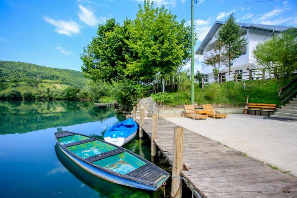 a boat sitting on the water next to a dock at Apartments River 1 in Bihać