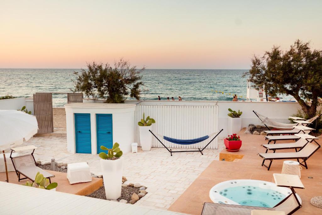 a patio with a hammock and the ocean in the background at Beauty Beach Villa in Monopoli
