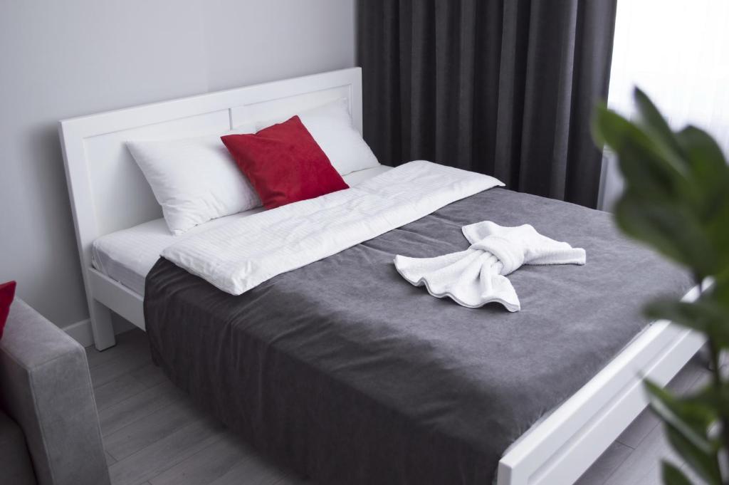 sypialnia z łóżkiem z 2 białymi i czerwonymi poduszkami w obiekcie Victory Apartment w mieście Zhensna Polʼska